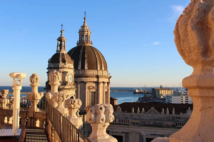 Blick von der Dachterrasse auf die Kuppel der Kathedrale von Catania und den Hafen dahinter.