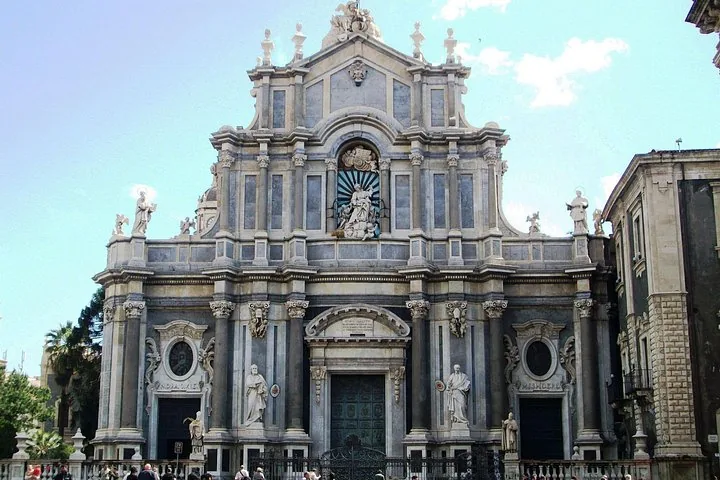 Die beeindruckende, detailreiche Fassade der Kathedrale von Catania mit mehreren Statuen.