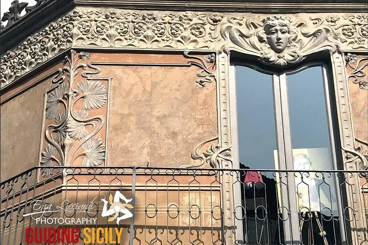 Dekorative Fassade eines Gebäudes mit filigranen floralen Schnitzereien und dem Gesicht einer Frau.